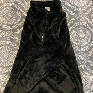 A black jacket that is fluffy and has a half zip up